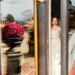 A bride is standing in front of a glass door.