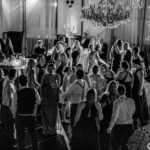 A black and white photo of people dancing in a ballroom.