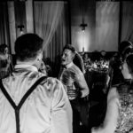 A group of people dancing at a wedding reception.