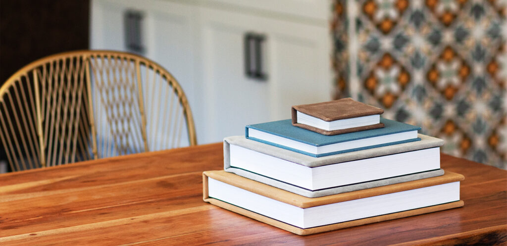 A stack of investment books on a wooden table.