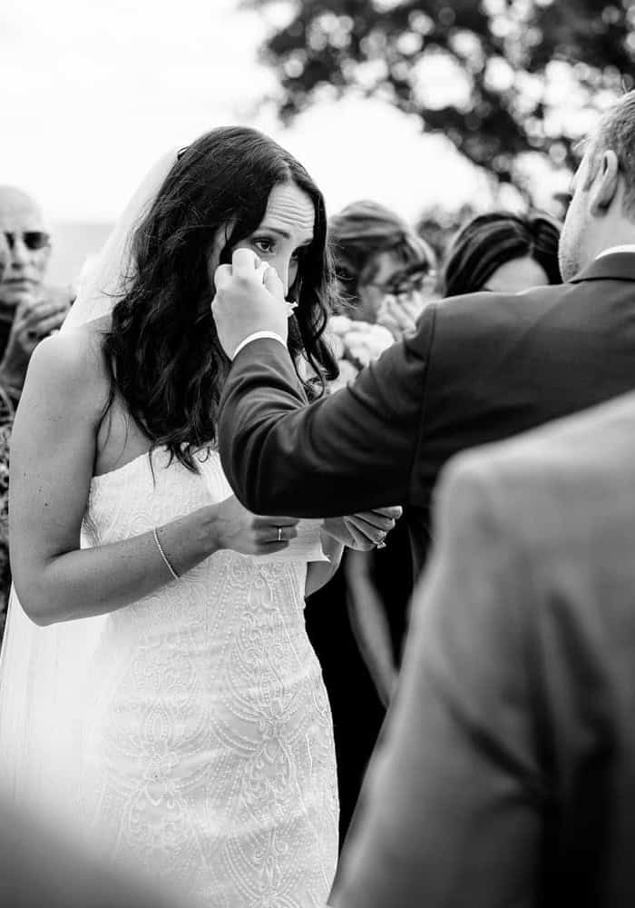 A bride is putting on her wedding ring.