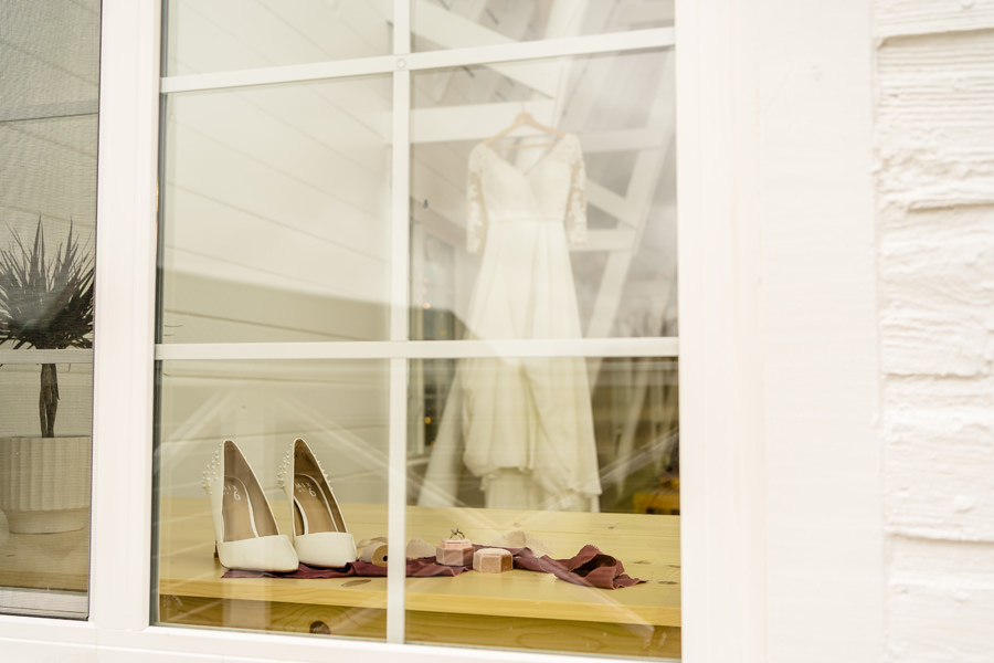 A wedding dress hanging in a window.