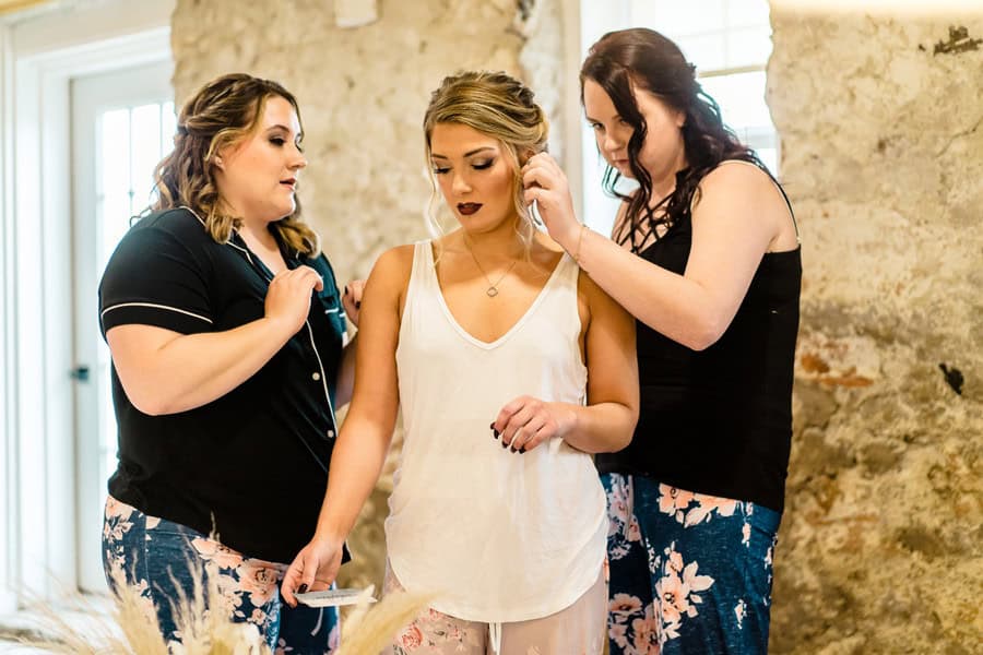 Three bridesmaids getting ready in pajamas.