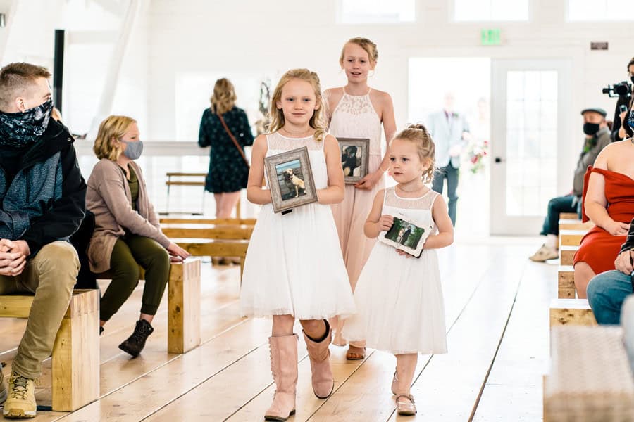 A bride and groom walk down the aisle with their flower girls.