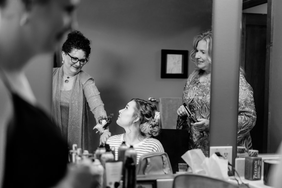 A bride getting ready in front of her bridesmaids.