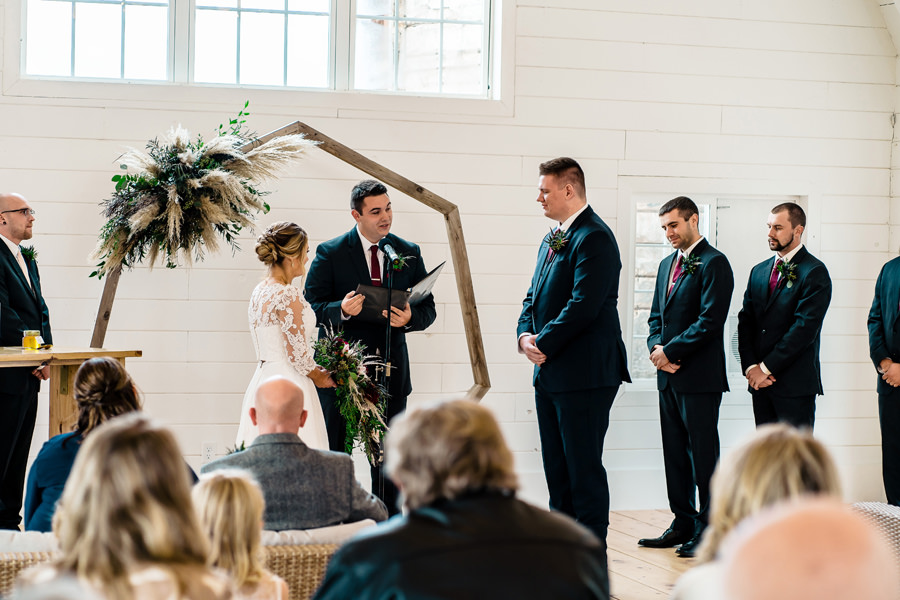A wedding ceremony in a barn with a bride and groom.
