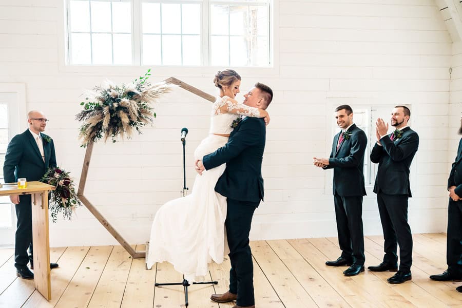 A bride and groom kiss during their wedding ceremony.