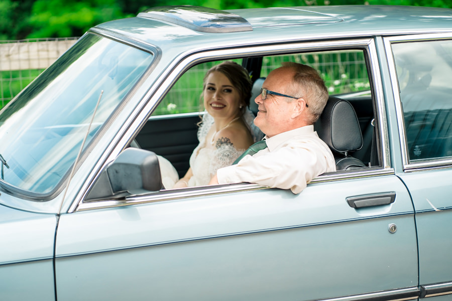 A bride and groom in a car.