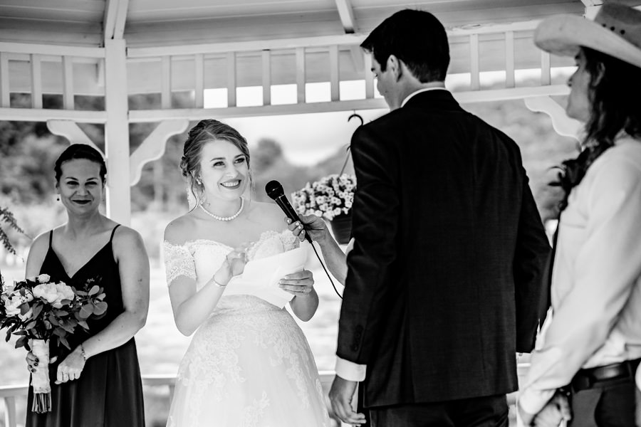 A bride and groom exchange vows in front of a gazebo.