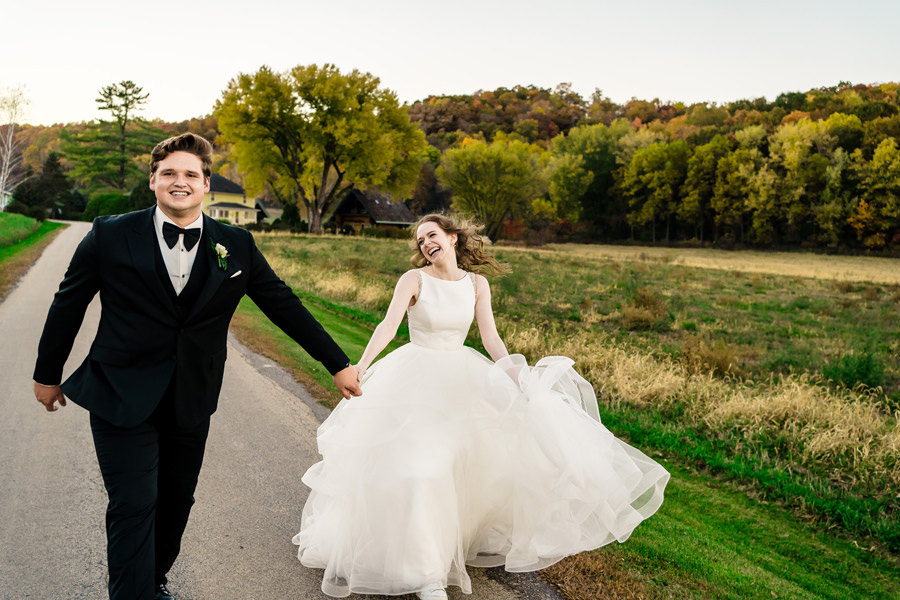 A bride and groom walking down a country road.