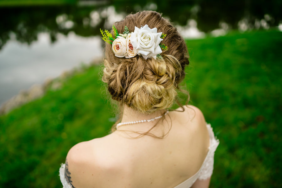 The back of a bride with a flower in her hair.