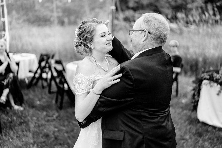 A black and white photo of a bride and her father dancing.