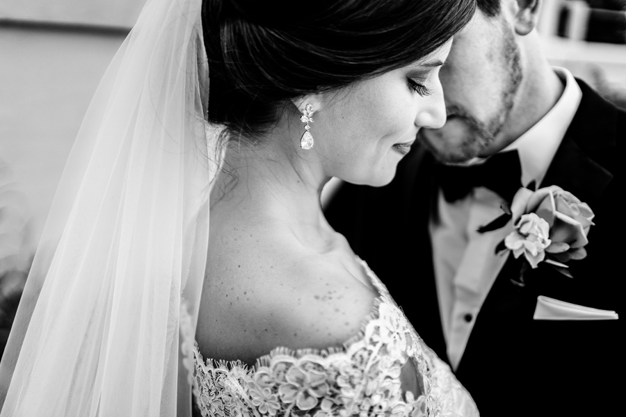 A black and white photo of a bride and groom kissing.