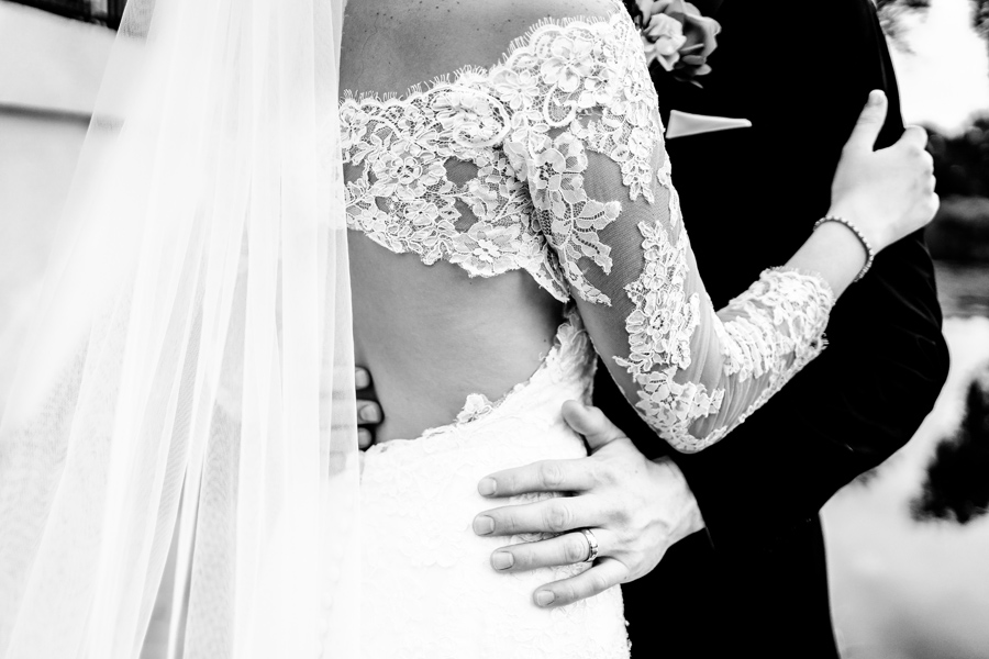 A black and white photo of a bride and groom hugging.