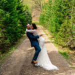 Courtney and James embrace on a forest path during their love-filled Trempleau wedding.