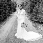 Courtney and James' bride standing in wedding dress on dirt road at Love-Filled Backyard Trempleau Wedding.