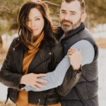 A couple embracing in the snow during their engagement session.