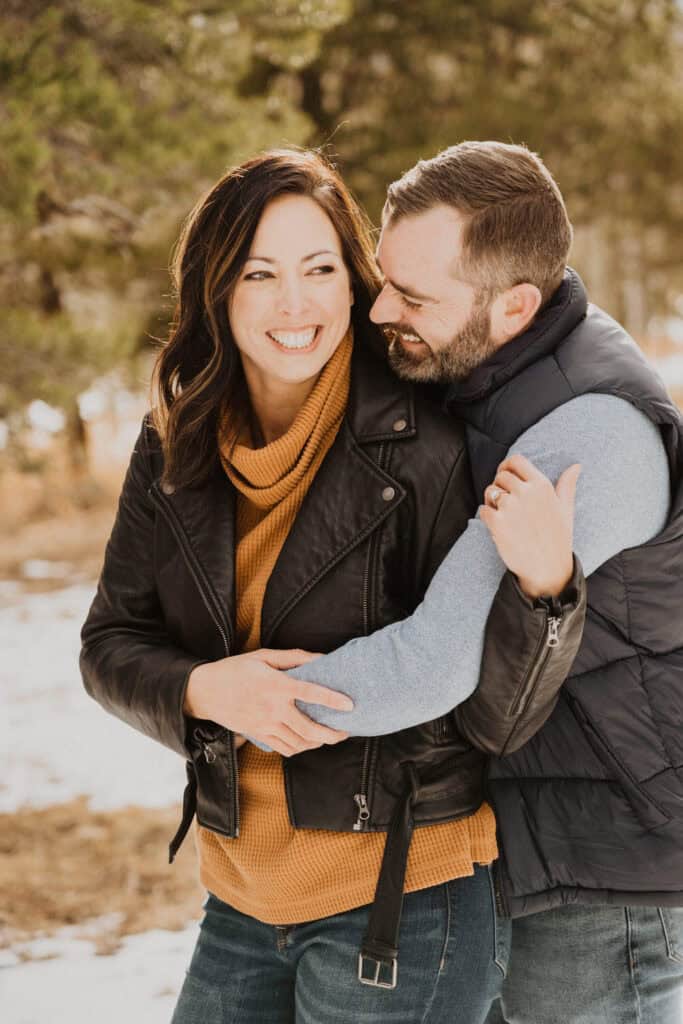 A couple embracing in the snow during their engagement session.