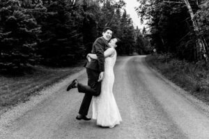 A bride and groom hugging on a country road.