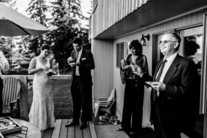 A bride and groom having a toast on a deck.