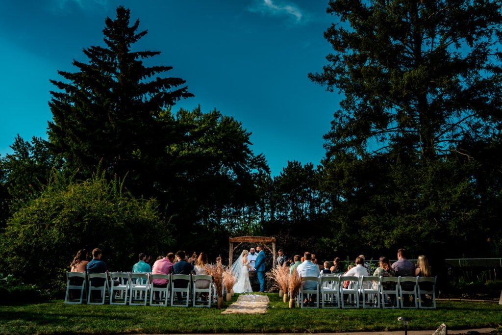 An emotional backyard wedding ceremony in La Crosse under a blue sky.