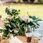An emotional backyard wedding in La Crosse with a table adorned with flowers and greenery.