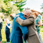 A man is embracing his father at an emotional backyard wedding in La Crosse.