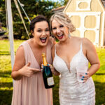 Two bridesmaids are laughing during an emotional backyard wedding in La Crosse.