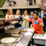 A love-filled backyard Trempleau wedding with a group of people preparing food on a grill.