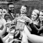 A black and white photo of Courtney and James toasting at their love-filled Trempleau wedding.