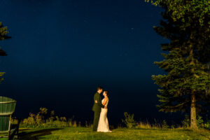 A bride and groom standing under a starry sky.