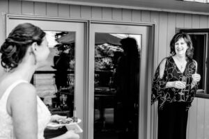 A bride is talking to a bridesmaid in a black and white photo.