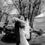A bride and groom kiss at a love-filled backyard wedding.