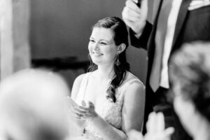 A bride clapping during her wedding speech.
