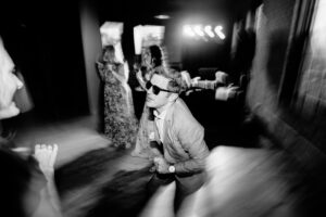 A man in sunglasses dancing at a party.