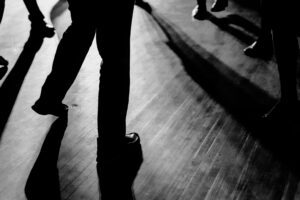 A black and white photo of people dancing on a dance floor.