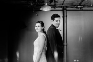 A bride and groom standing in a dark room.