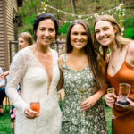 Three women posing for a photo at a love-filled backyard party.