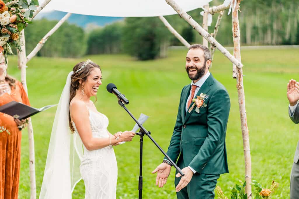 A bride and groom exchange vows in a field.