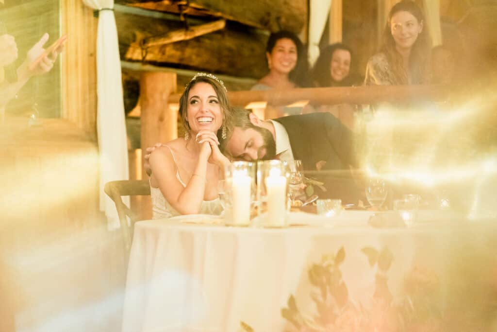 A bride and groom laughing at their wedding reception.