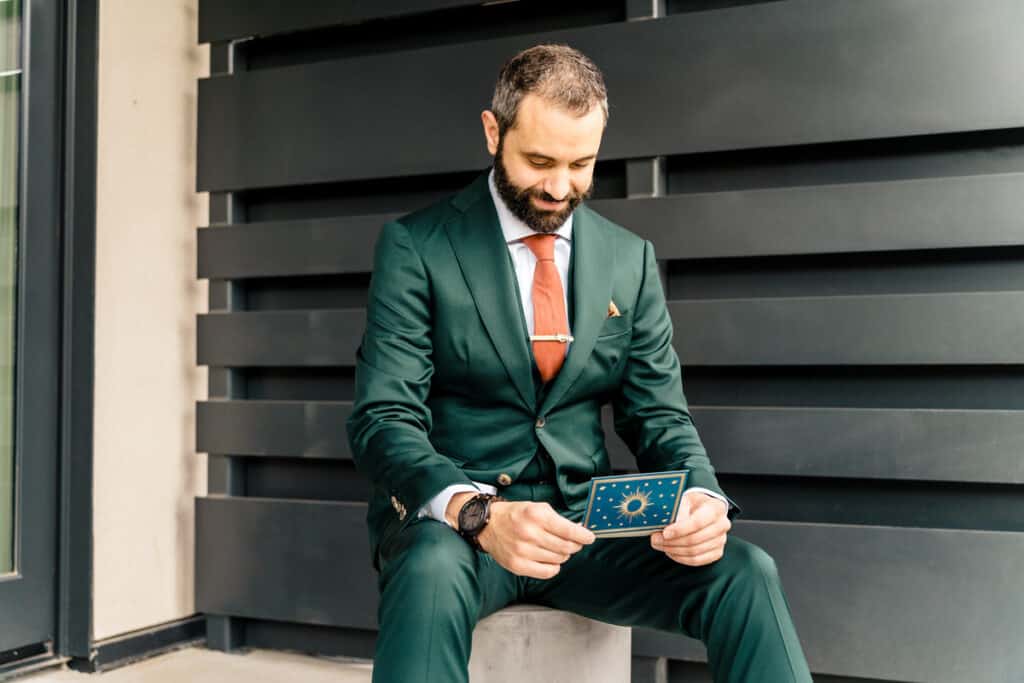 A man in a suit sitting on a stone.