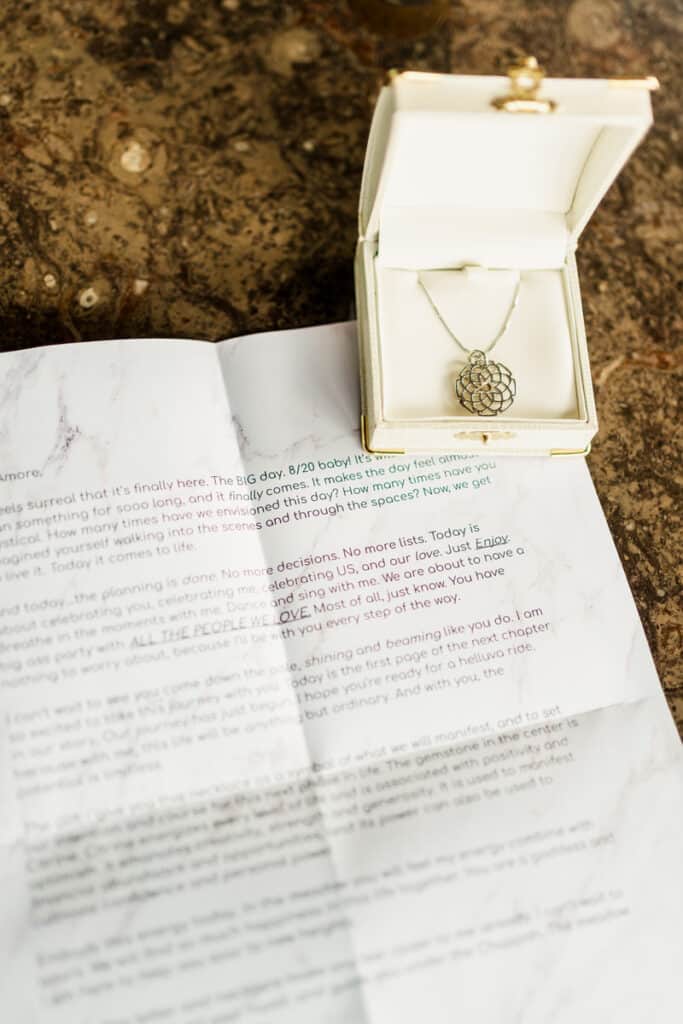 A letter with a necklace sitting on top of it.