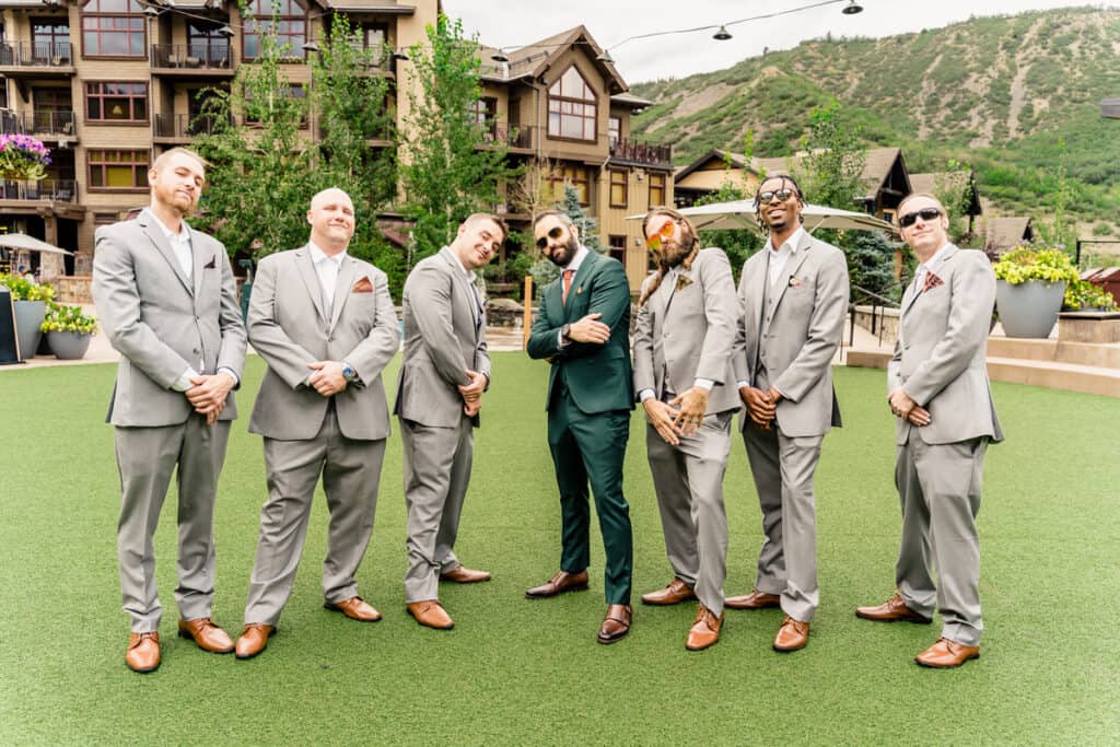 A group of groomsmen posing in front of a building.