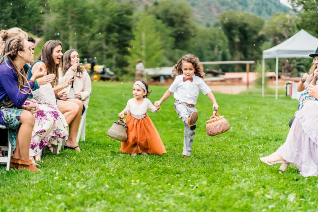 A little girl is running down the aisle during a wedding ceremony.