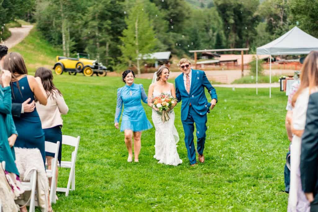 A bride and groom walking down the aisle at a wedding.