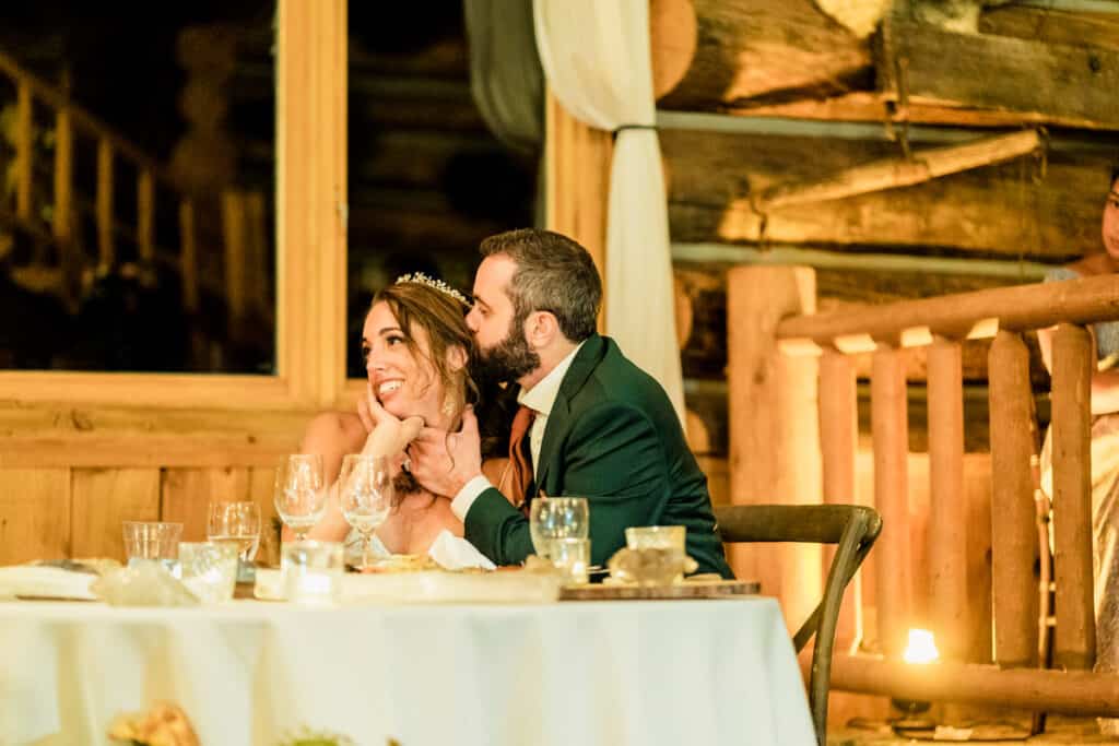 A bride and groom sharing a kiss at their wedding reception.