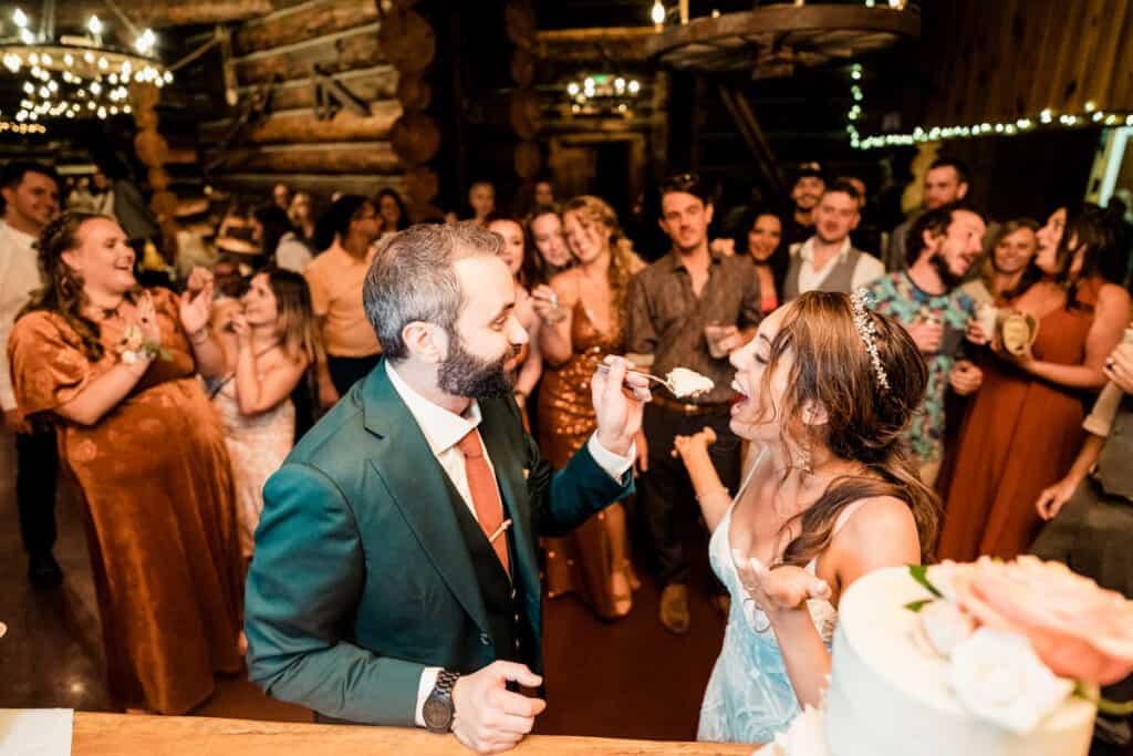 A bride and groom feeding each other their wedding cake.