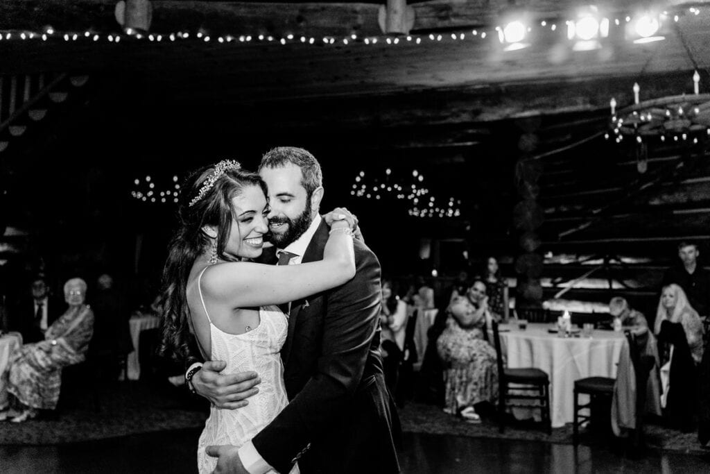 A bride and groom sharing their first dance in a log cabin.