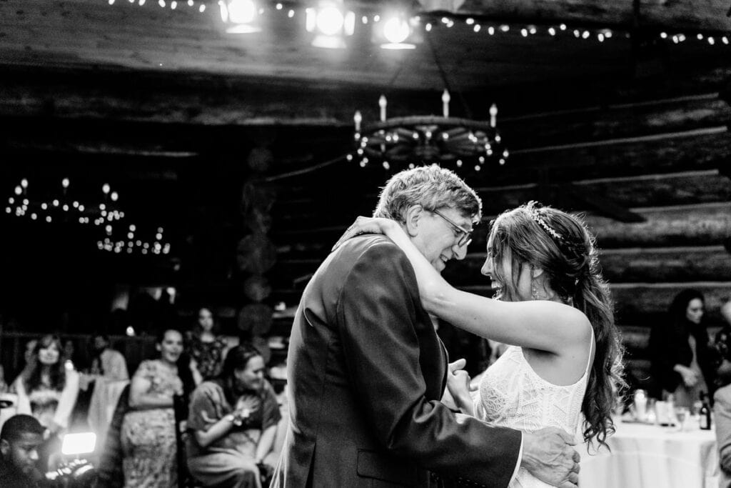 A bride and groom sharing their first dance in a log cabin.