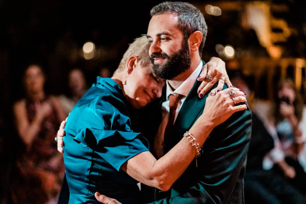 A man and woman hugging at a wedding reception.